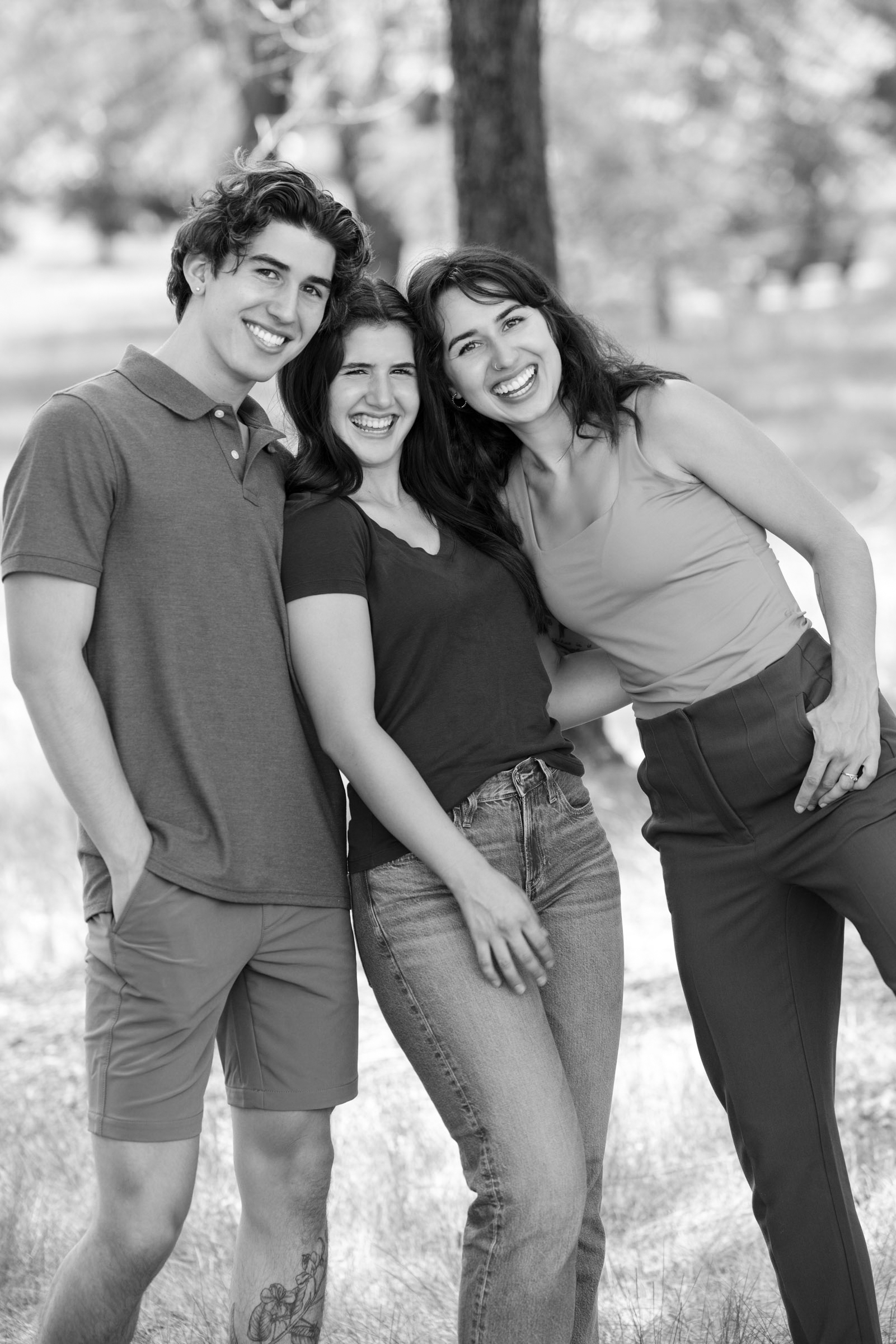 Brother and sisters standing together outdoors during a portrait session.