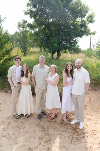 Extended family standing together outdoors during a portrait session.