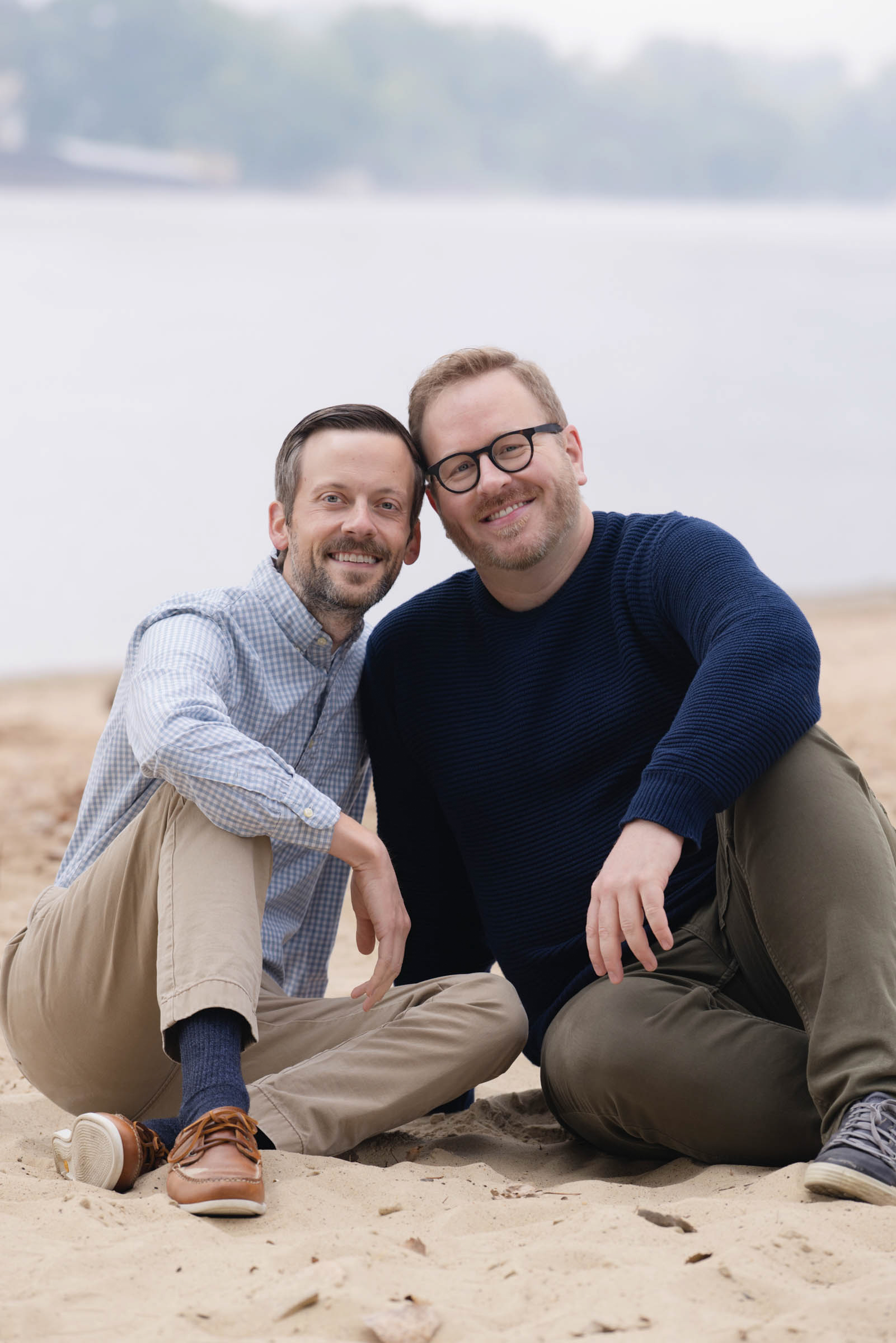 Couple sitting together and smiling during an outdoor portrait session.