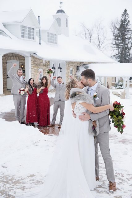 Bride and groom celebrating with family and friends outdoors during a winter wedding.