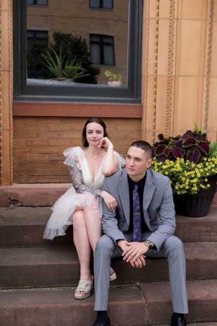 Bride and groom sitting together outside during their wedding day.