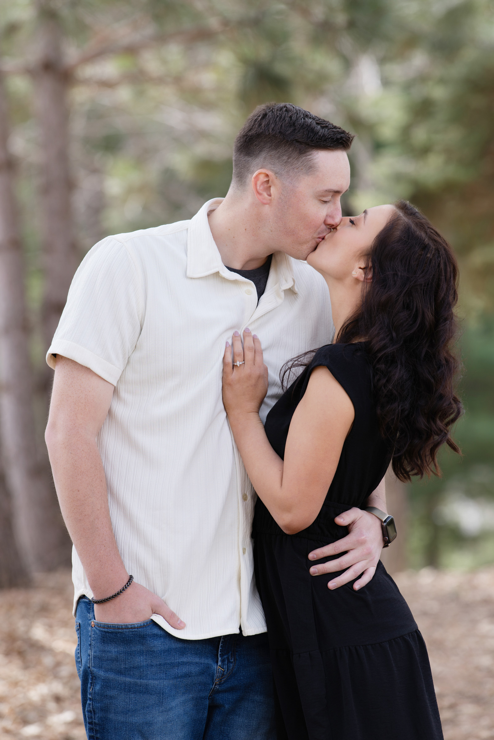 Engaged couple sharing a kiss during an outdoor engagement portrait session.