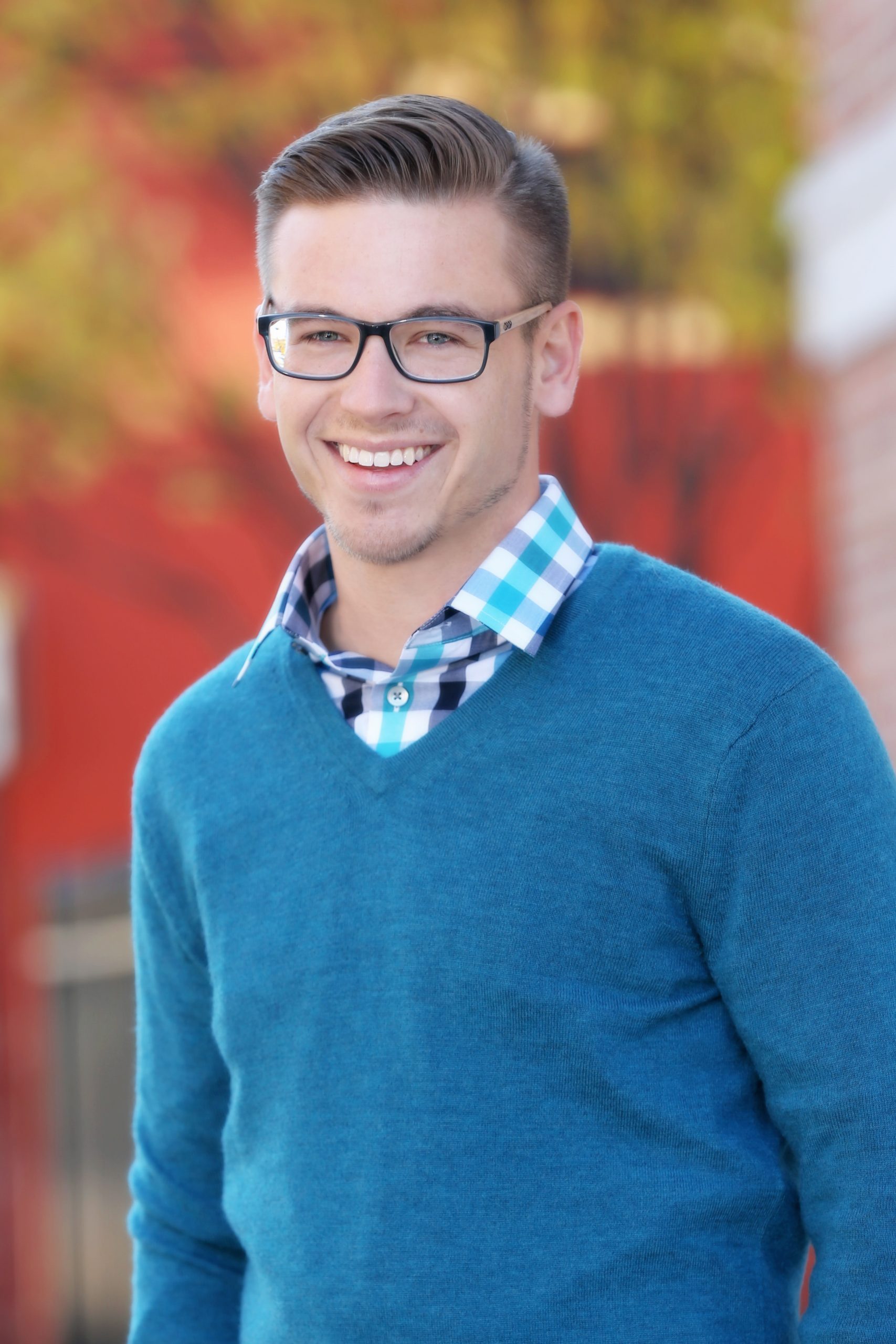 Professional headshot of a man smiling outdoors.