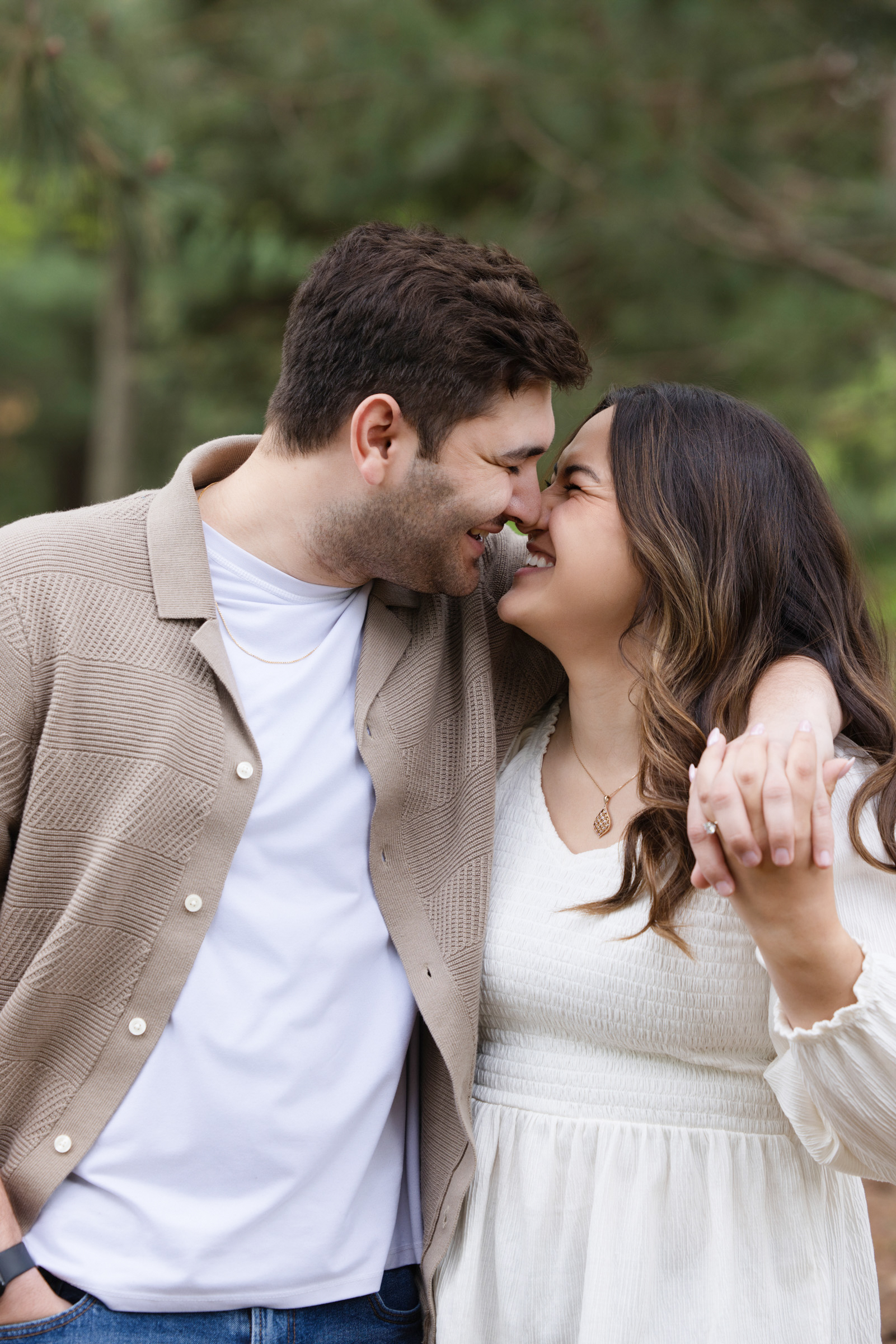 Engaged couple smiling during an outdoor engagement session.