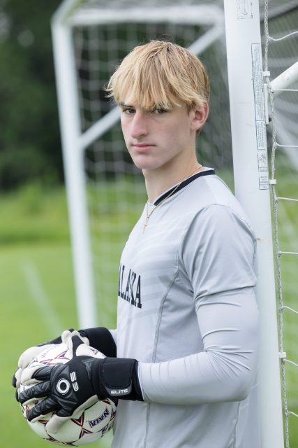 High school senior in an athletic uniform during a portrait session.