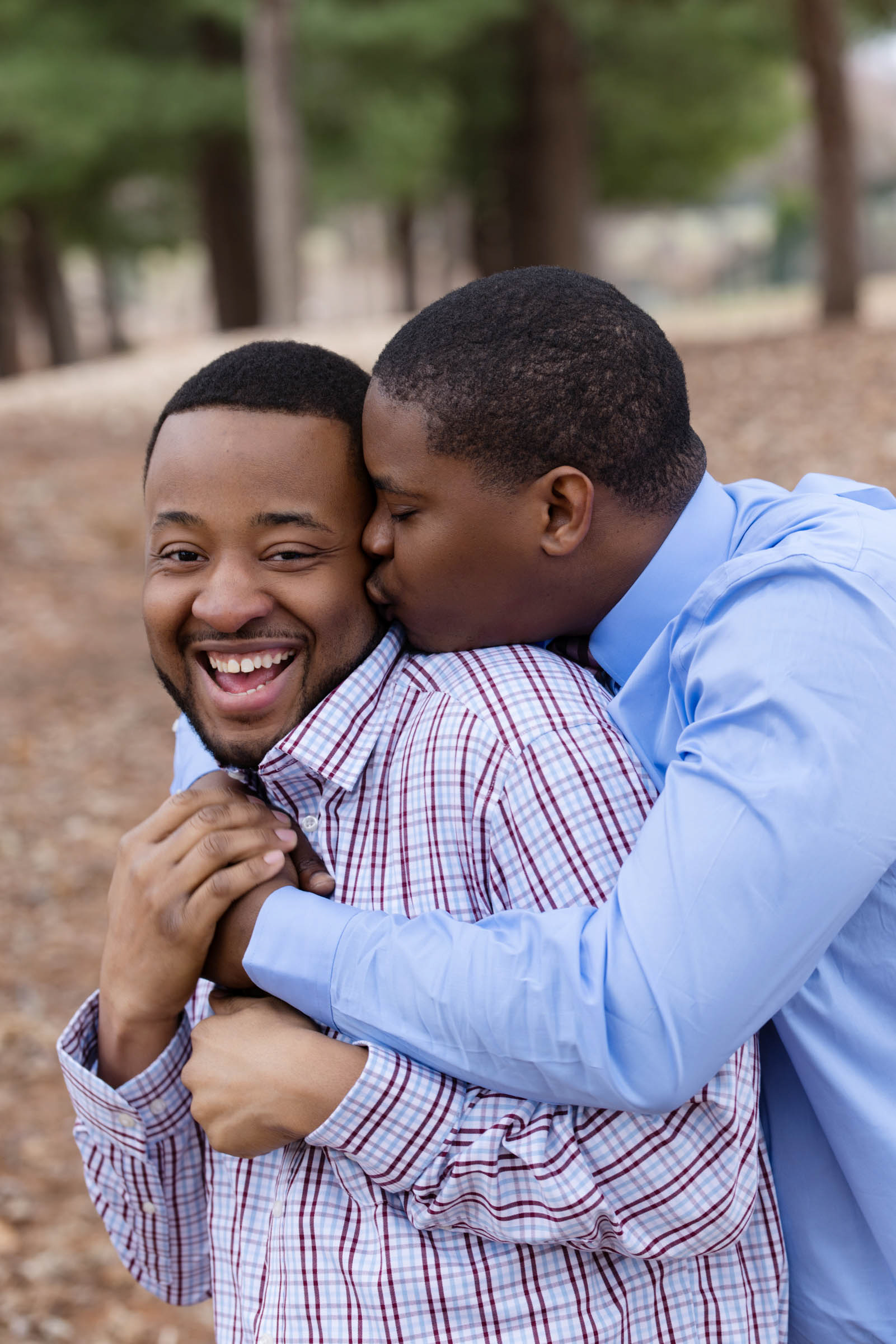 Engaged couple laughing together during an outdoor engagement session.