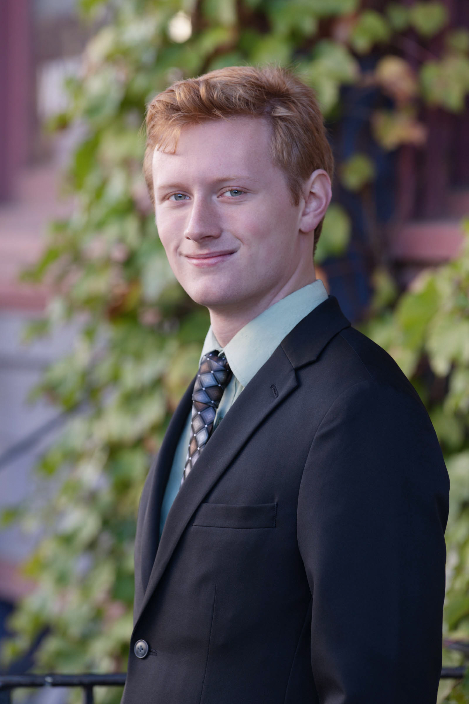 High school senior wearing a suit and tie during an outdoor portrait session.