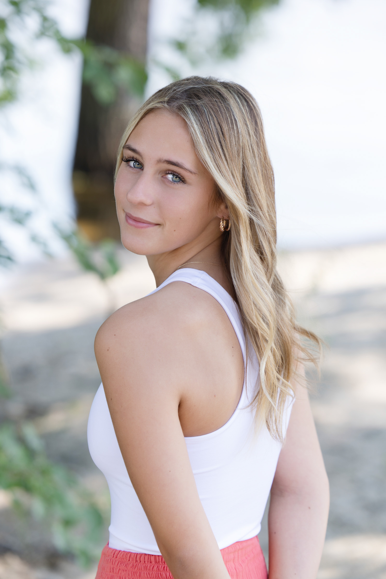 Close-up portrait of a high school senior smiling toward the camera during an outdoor portrait session.