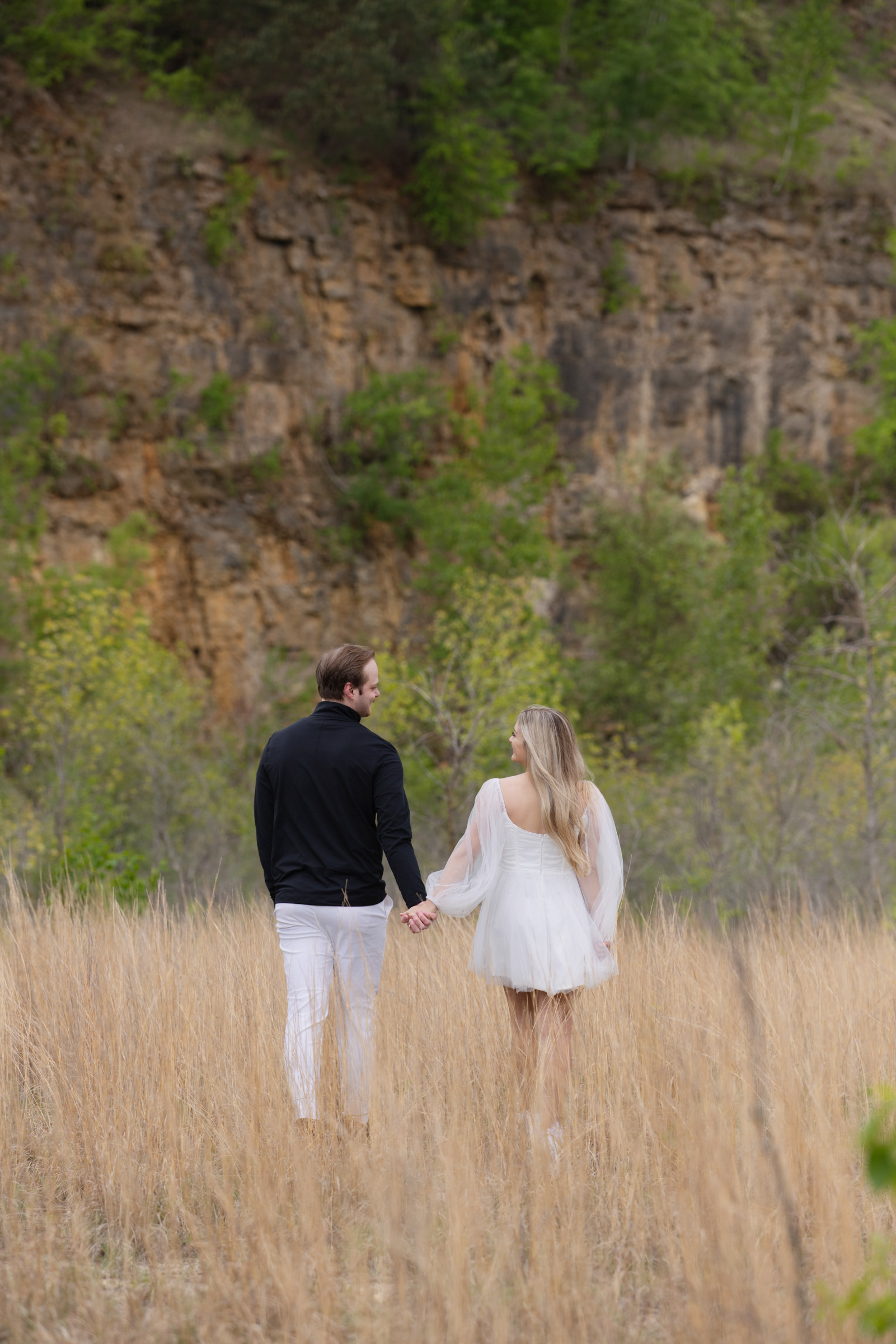 Engaged couple walking away together during an outdoor engagement portrait session.