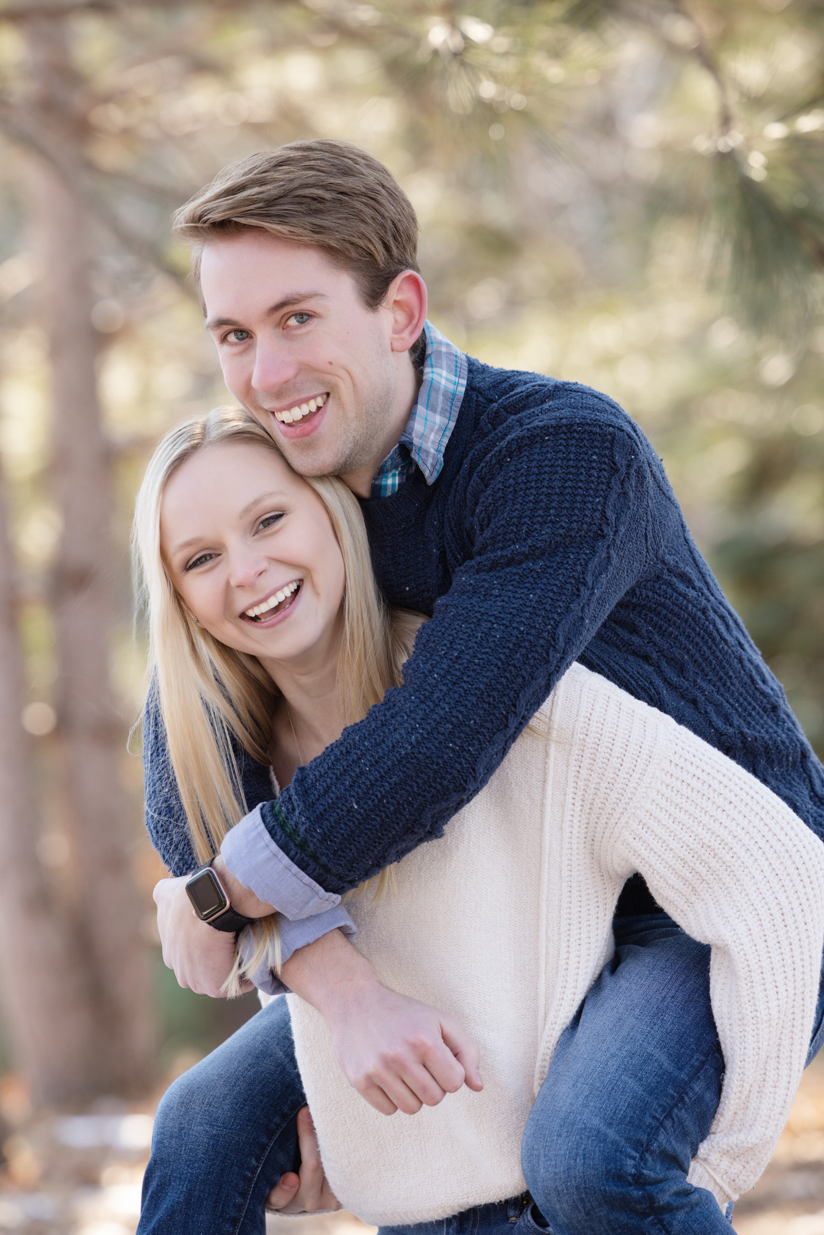 Engaged couple smiling during a playful, fun moment in their engagement session.