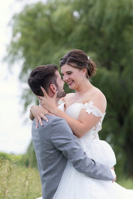 Bride smiling at the groom during an outdoor wedding portrait.